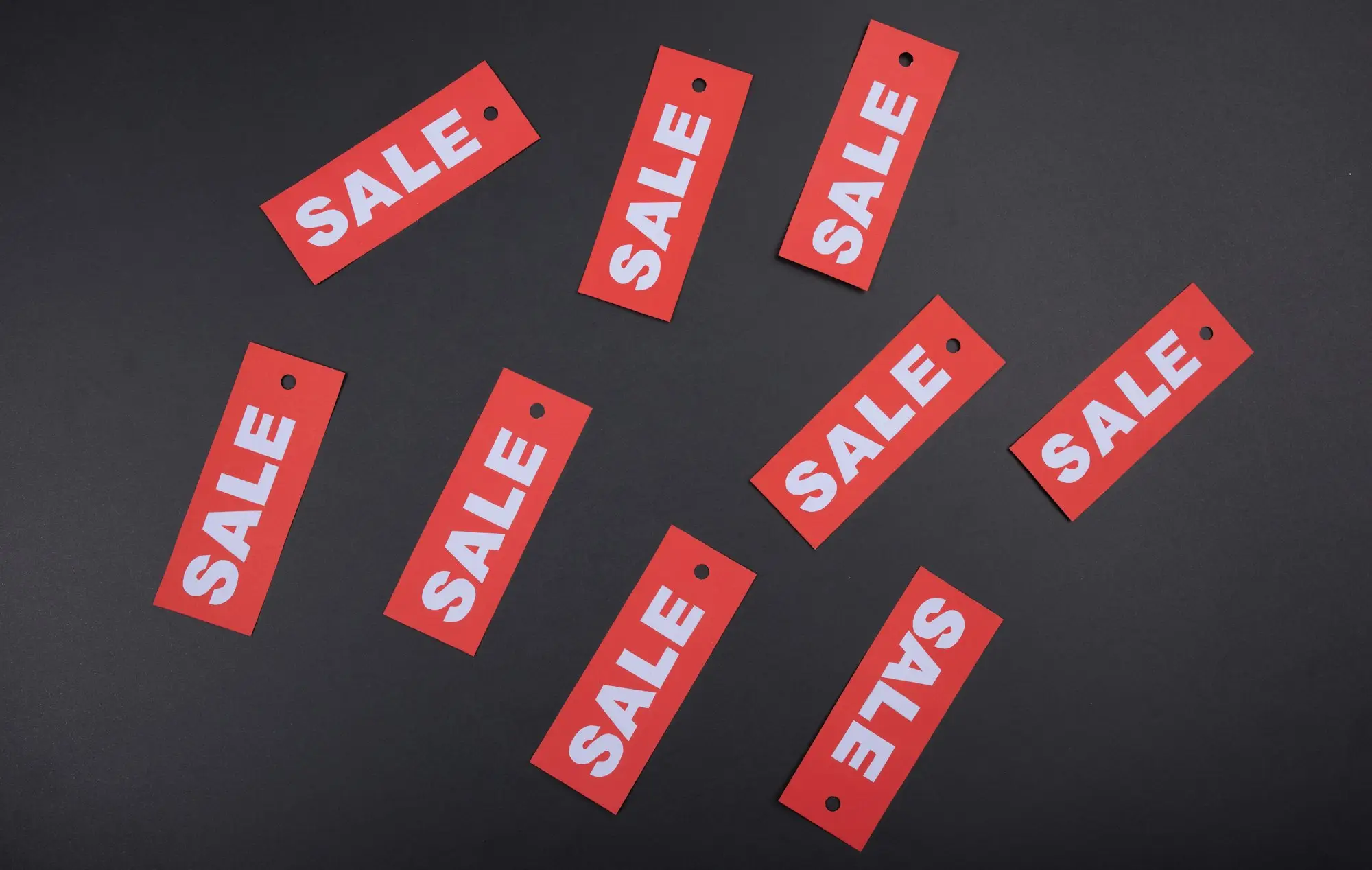 Red Black Friday sale swing tags scattered across a dark table before an online store sets its discounts
